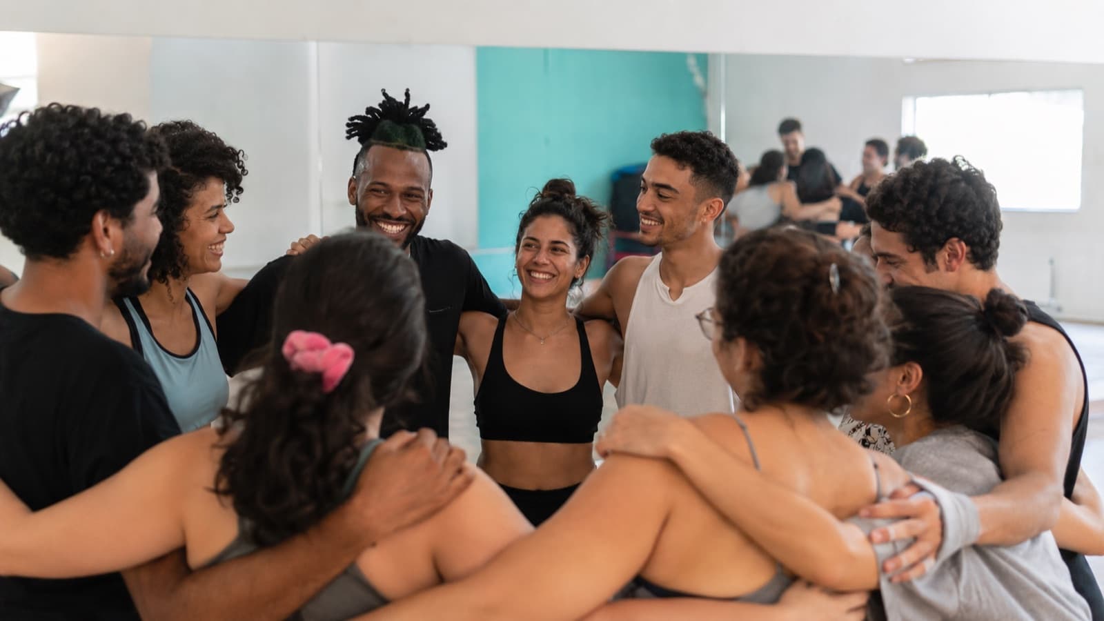 Turma de dança em roda, alunas sorrindo juntas, representando pertencimento e vínculo