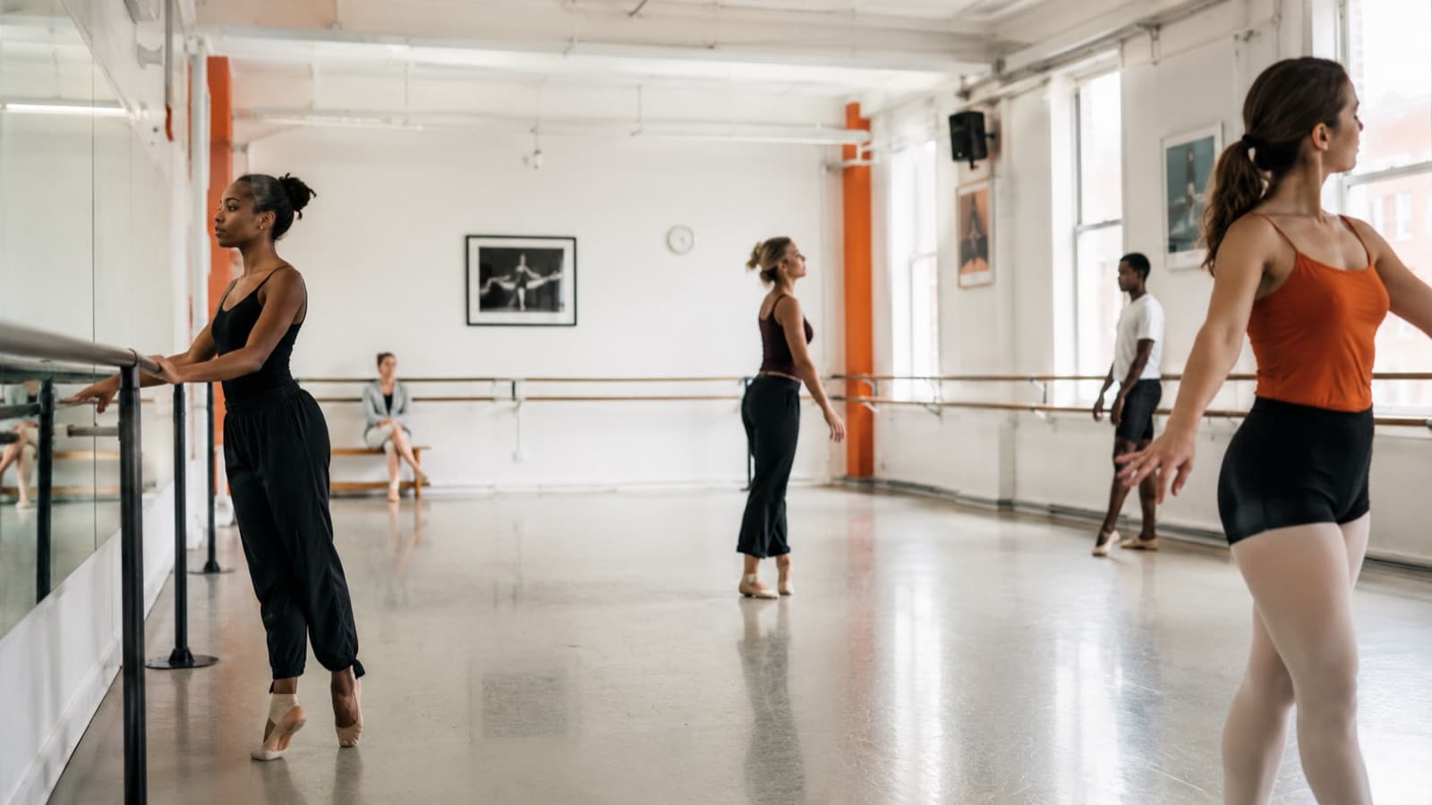 Professor de dança de saída de um estúdio, com sala de dança ao fundo