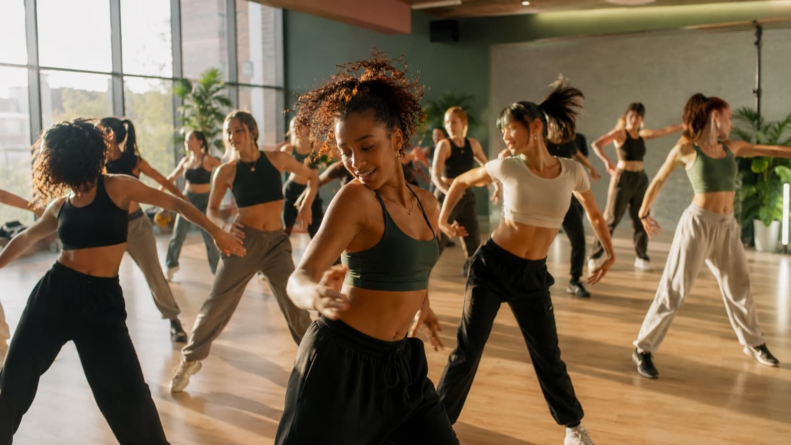 Aluna de ballet observando uma turma de jazz na sala ao lado da escola de dança